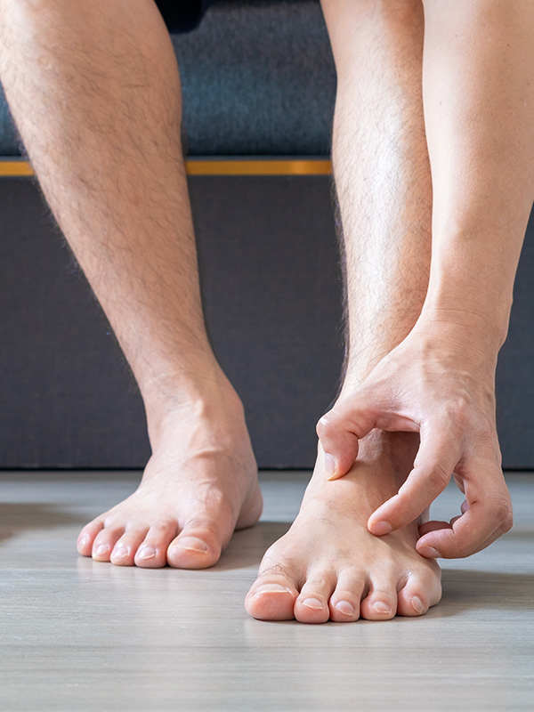Man scratching legs and feet with itchy skin